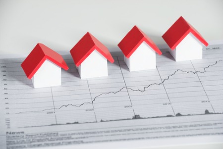 real estate market report concept with small houses on graph